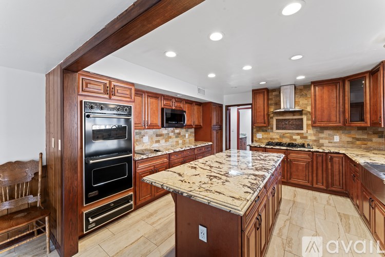 A kitchen with wooden cabinets and a granite countertop.