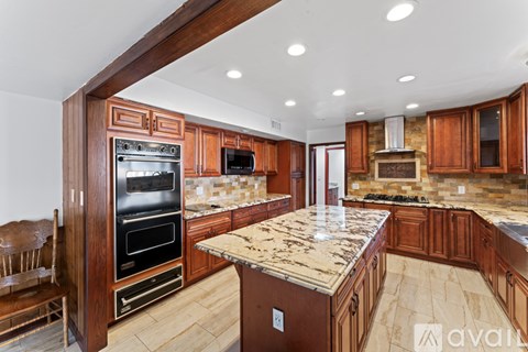 A kitchen with wooden cabinets and a granite countertop.