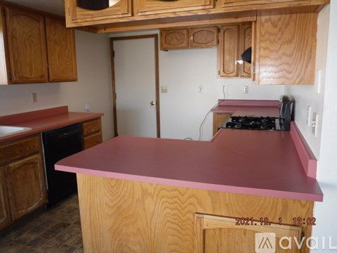 A kitchen with wooden cabinets and a red countertop.