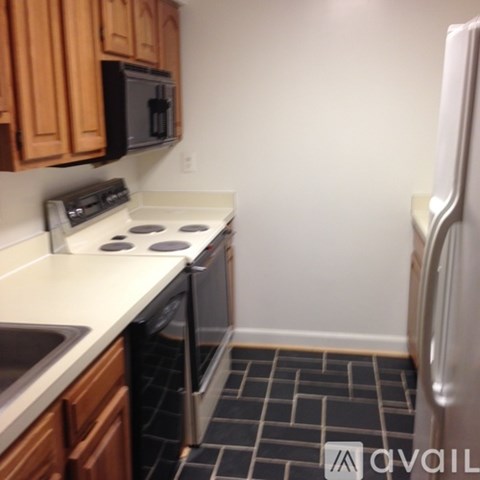 A kitchen with a stove top oven and a refrigerator.