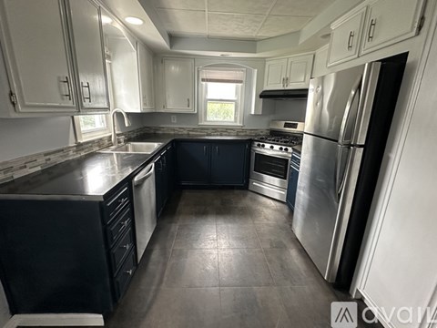 A kitchen with a black countertop and stainless steel appliances.