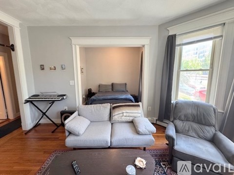 A living room with a grey couch and a black coffee table.