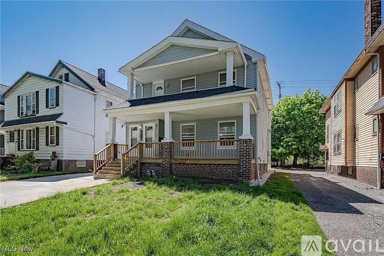 A two-story house with a front porch is for sale.