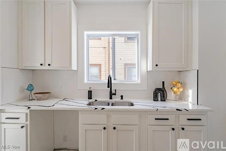 A kitchen with white cabinets and a white countertop.