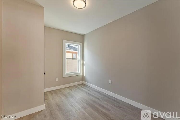 A room with a window and wooden flooring.