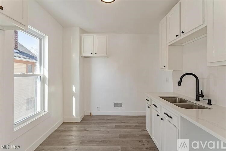 A kitchen with white cabinets and a sink.