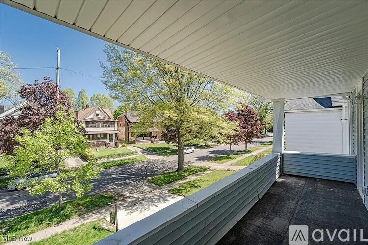 A view from a covered porch looking out at a residential street.