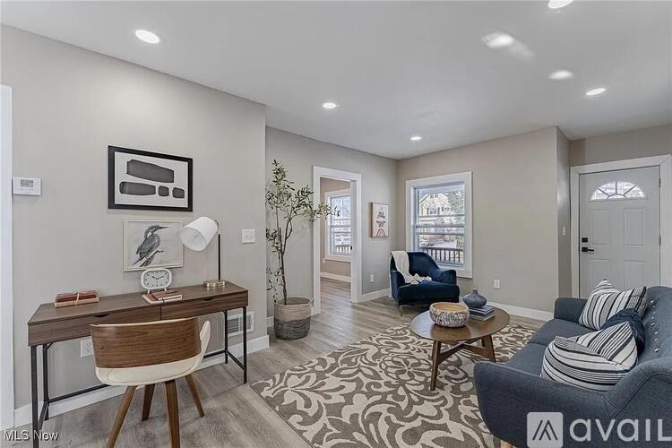 A living room with a couch, a desk, and a rug.