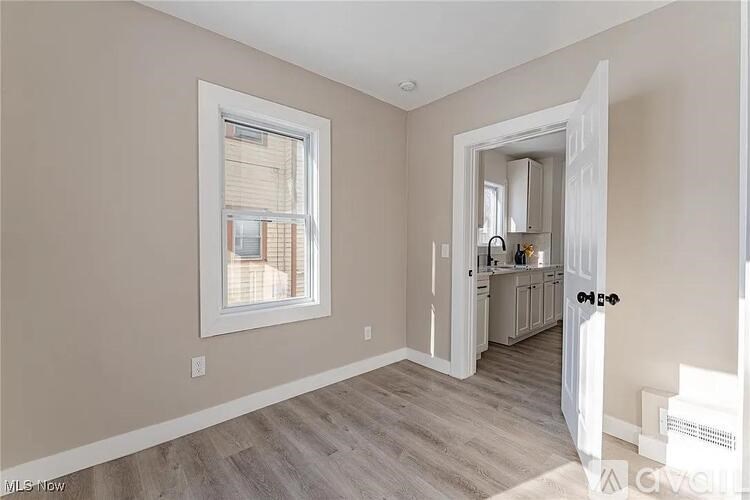 A room with a window and a door leading to another room.