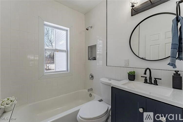 A bathroom with a white tub, toilet, and sink.