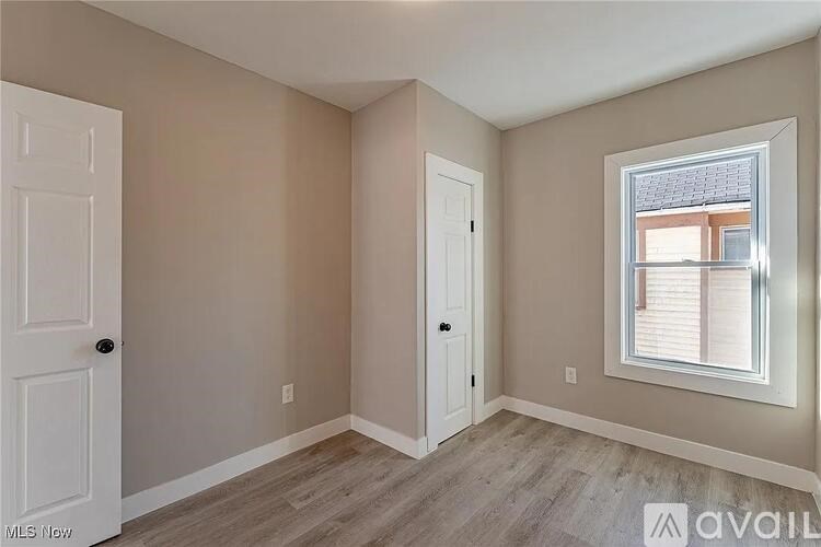 A room with a window and two doors.