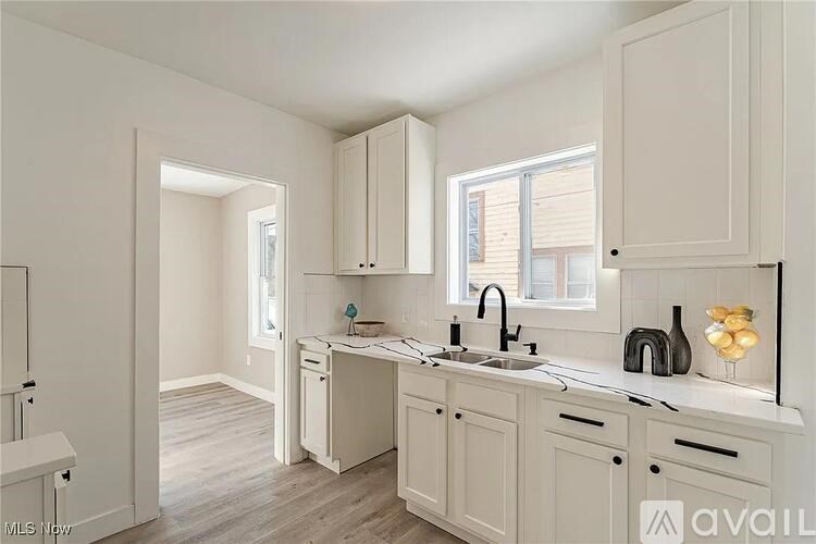 A kitchen with white cabinets and a sink.