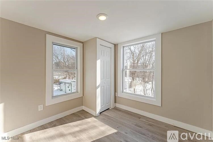A room with a door and a window showing a snowy landscape.