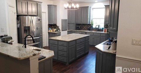 A kitchen with a granite countertop and a refrigerator.