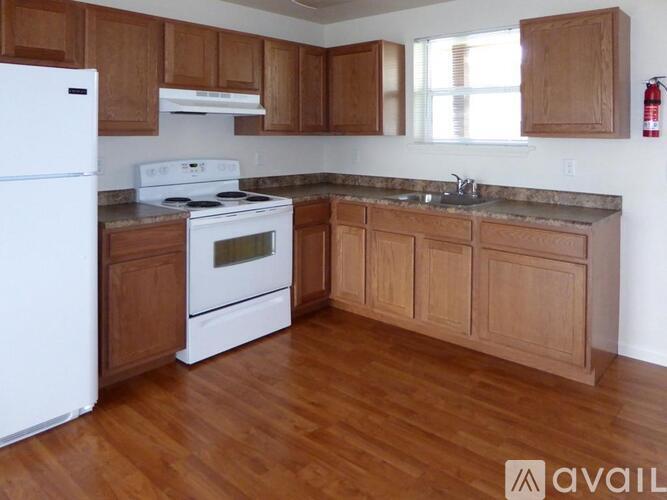 A kitchen with wooden cabinets and a white stove top oven.