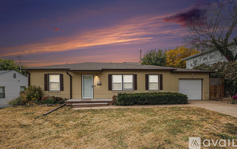A house with a front yard and a garage is available for sale.