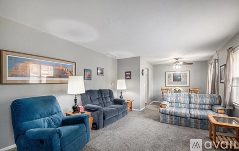 A living room with a blue chair and a grey sofa.