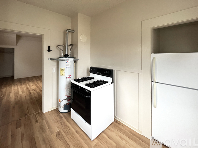A white kitchen with a stove and a refrigerator.