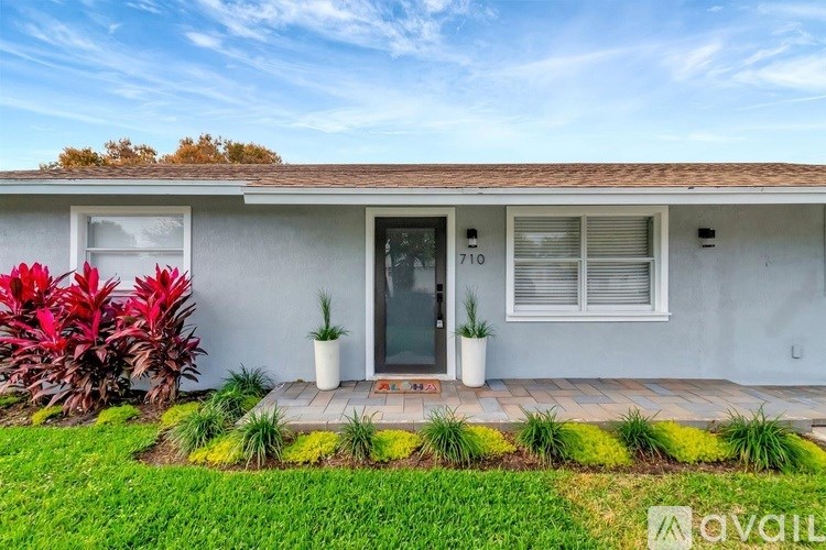 A house numbered 710 with a front yard and a small garden.