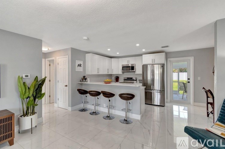 A modern kitchen with a bar area and a dining table.