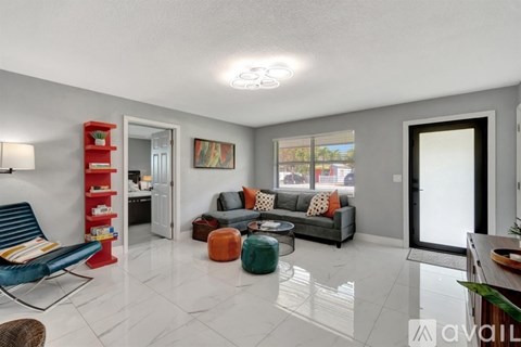 A living room with a blue chair and a red shelf.