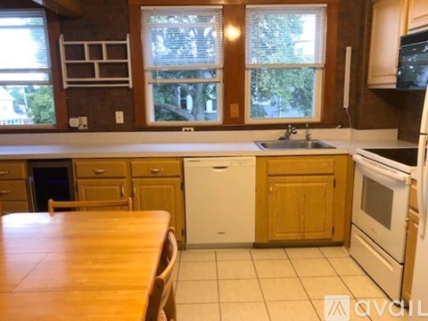A kitchen with a wooden table and white appliances.