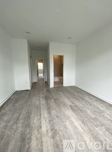 A hallway with wood flooring and white walls.