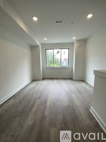 A room with wooden flooring and a window.