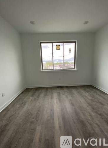 A room with a window and wooden flooring.