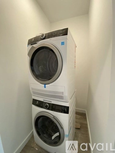 A stack of two washing machines in a small room.