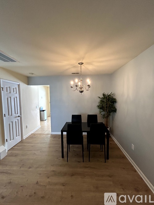 A dining room with a table and chairs and a chandelier.