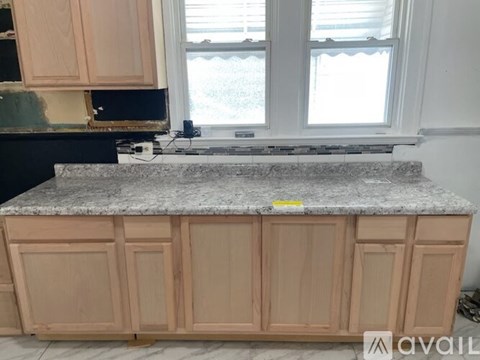 A kitchen island with wooden cabinets and a granite countertop.