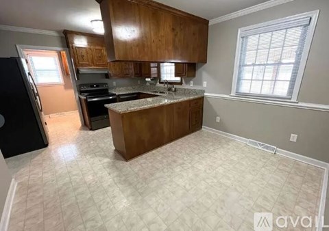 A kitchen with wooden cabinets and a granite countertop.
