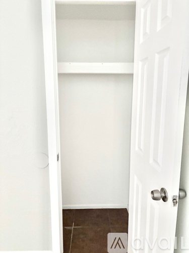 A white door with a handle and a mat on the floor.