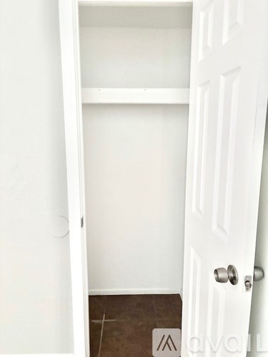 A white door with a handle and a mat on the floor.