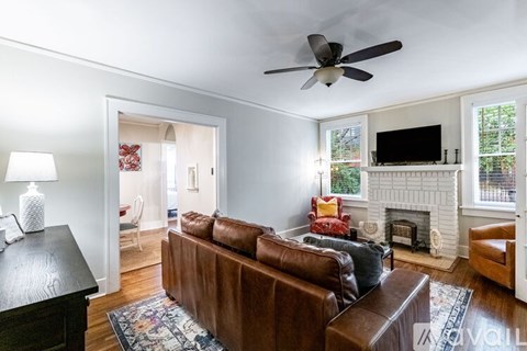 A living room with a brown couch and a fireplace.