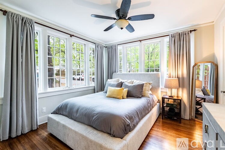 A bedroom with a large bed and a ceiling fan.