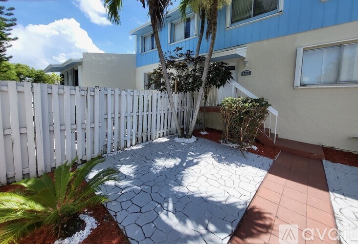 A white picket fence surrounds a small garden area.