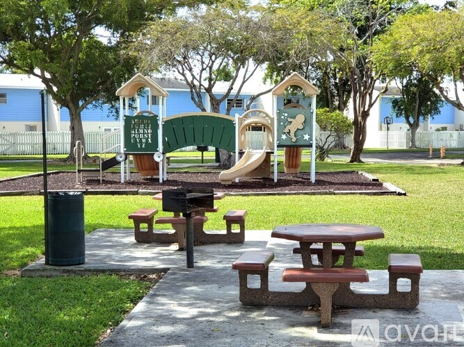 A playground with a green slide and a picnic table.