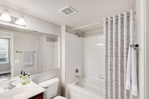 A white bathroom with a sink, toilet, and bathtub.