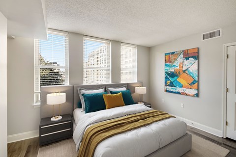 A bedroom with a large bed and a painting on the wall.