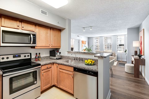 A kitchen with wooden cabinets and a black dishwasher.