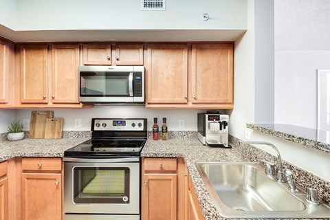 A kitchen with wooden cabinets and a stove top oven.