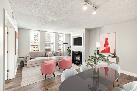 A living room with a grey table and pink chairs.