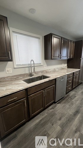 A kitchen with brown cabinets and a marble countertop.