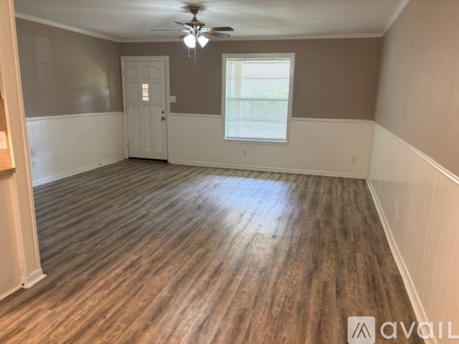 A room with wooden flooring and a ceiling fan.