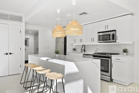 A kitchen with white cabinets and a marble countertop.