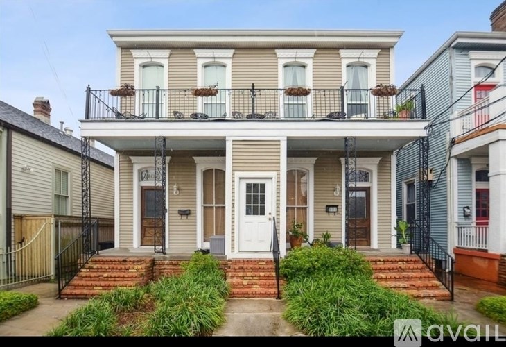 A two-story house with a front porch and a balcony.