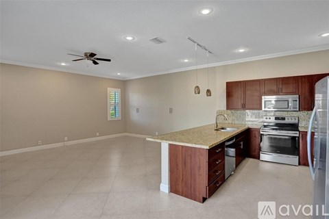 A kitchen with a refrigerator, oven, and microwave.