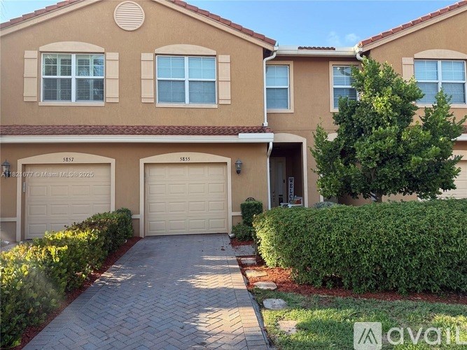 A two-story house with a driveway in front.